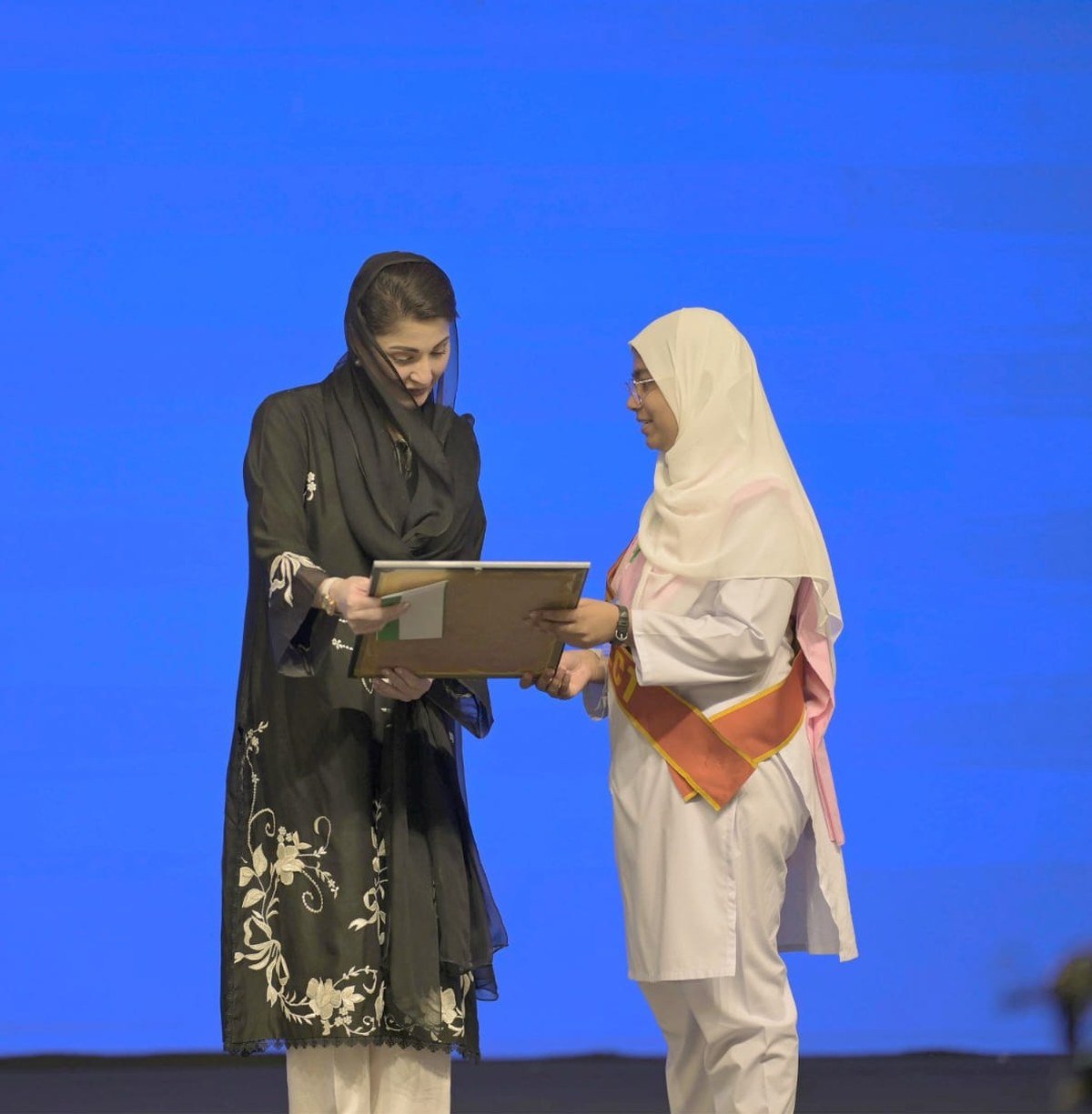 The chief minister presents a portrait to a student at the University of Rasul ceremony