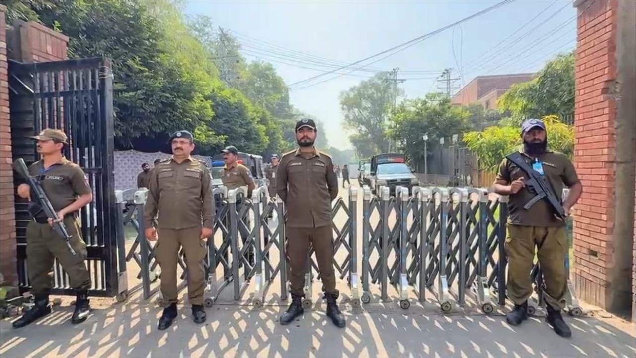 Armed officers at a Gaddafi Stadium gate barrier