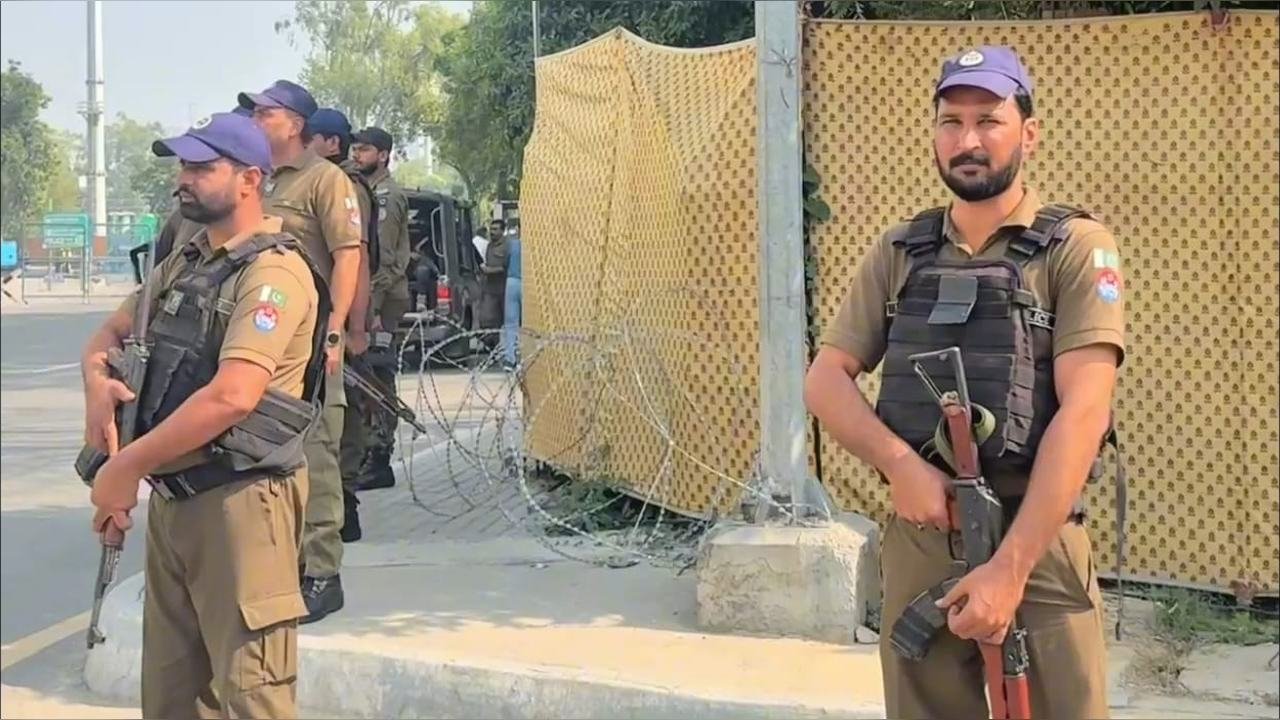 Armed officers on duty beside a road near Gaddafi Stadium