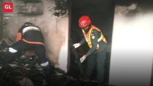 Rescue 1122 worker clearing debris inside a burnt house in Faisalabad