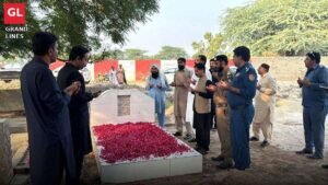 Officers offer Fateha at the grave of martyred Traffic Warden Musawwar Hussain in Samundri