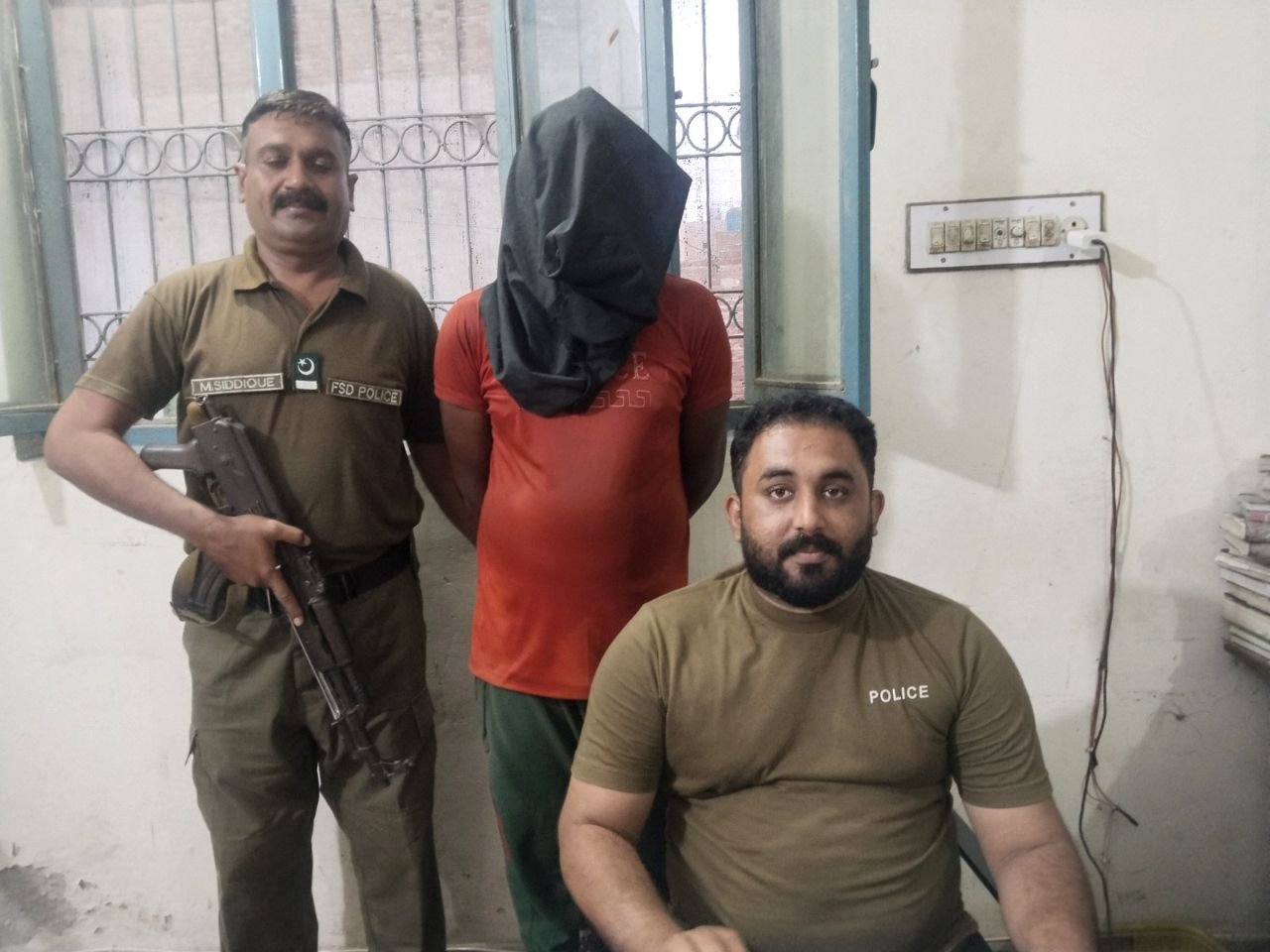 Faisalabad police with an arrested suspect