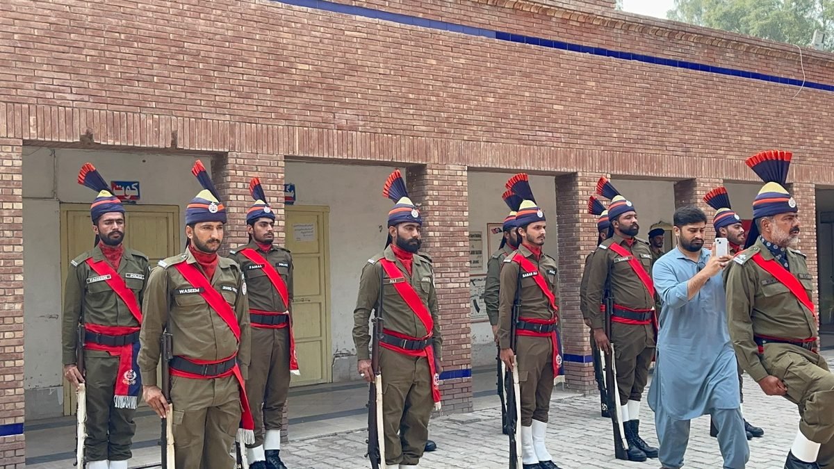 A police contingent presents a guard of honour to the RPO in Jhang