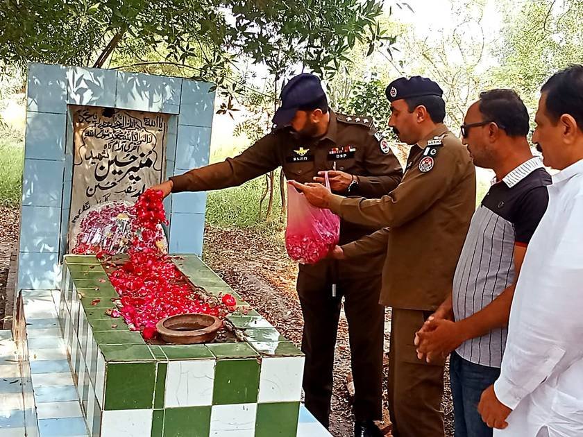 Rose petals being showered on the grave of martyred Constable Munir Ahmed in Jaranwala