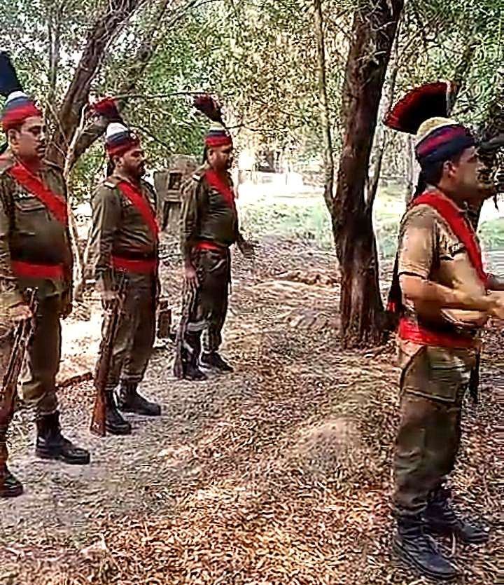 Police guard presenting a salute on the death anniversary of martyred Constable Munir Ahmed