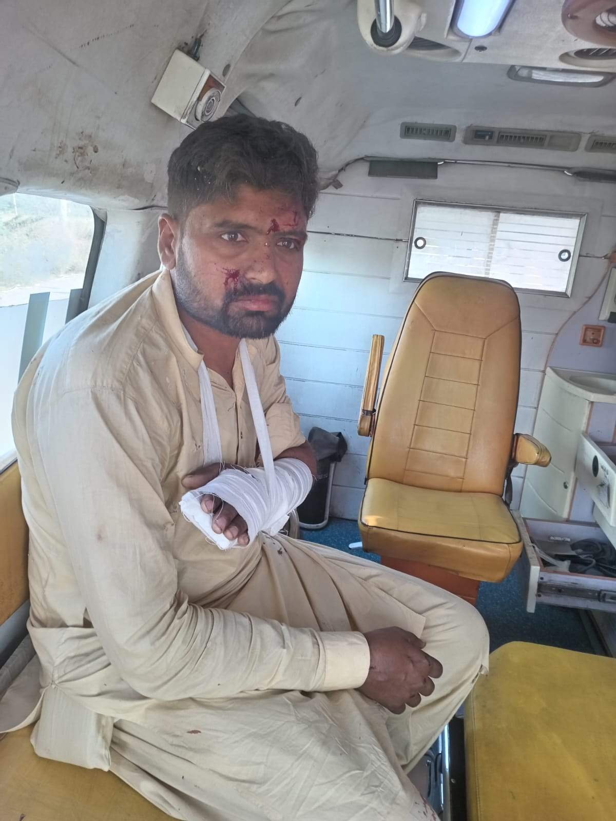 Injured man with a bandaged arm inside an ambulance after the Chak Jhumra collision