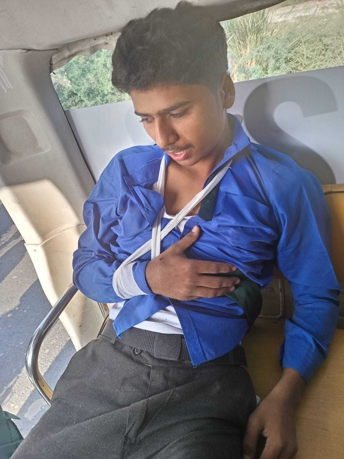 Injured young man with his arm in a sling inside an ambulance