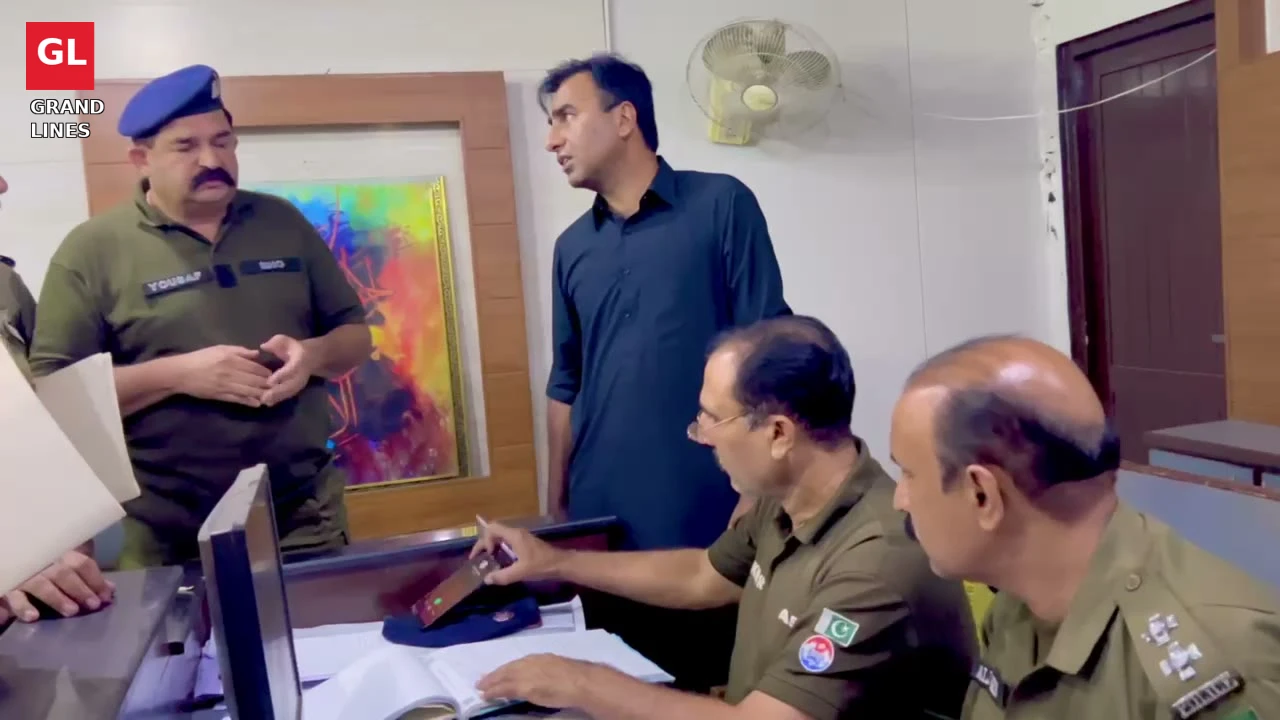 SSP Operations Imran Ahmad Malik speaks to officers at a police station front desk in Faisalabad.