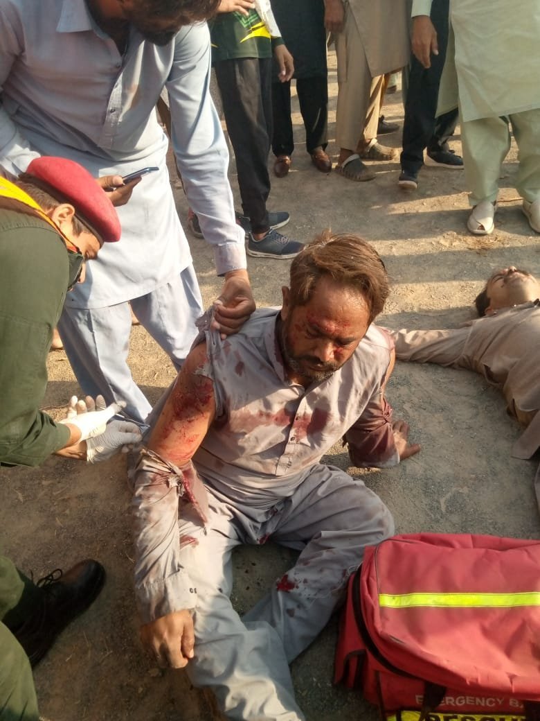 Rescue 1122 worker attending an injured man at the Chak Jhumra accident site