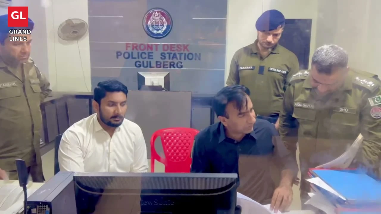 SSP Operations Imran Ahmad Malik inspects files at the Gulberg police station front desk.