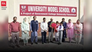 Vice Chancellor Prof. Dr. Rauf-i-Azam holds a bouquet presented by a student in front of the University Model School board at GCUF