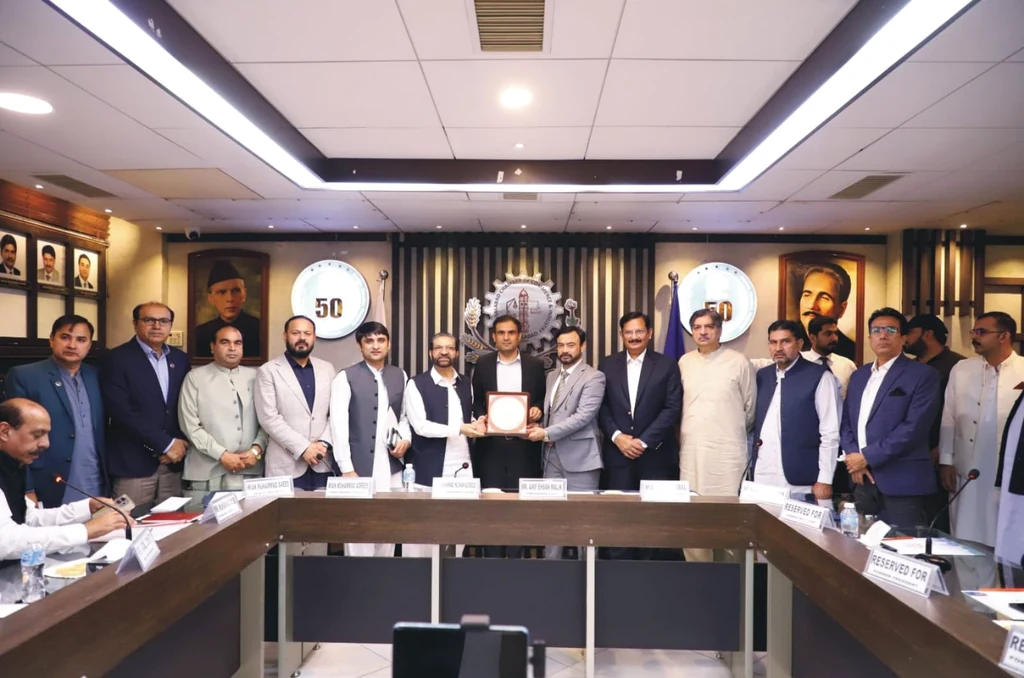 FCCI President Arif Ehsan Malik presents an honorary shield to Deputy Commissioner Muhammad Numan Siddiq at the Faisalabad chamber.