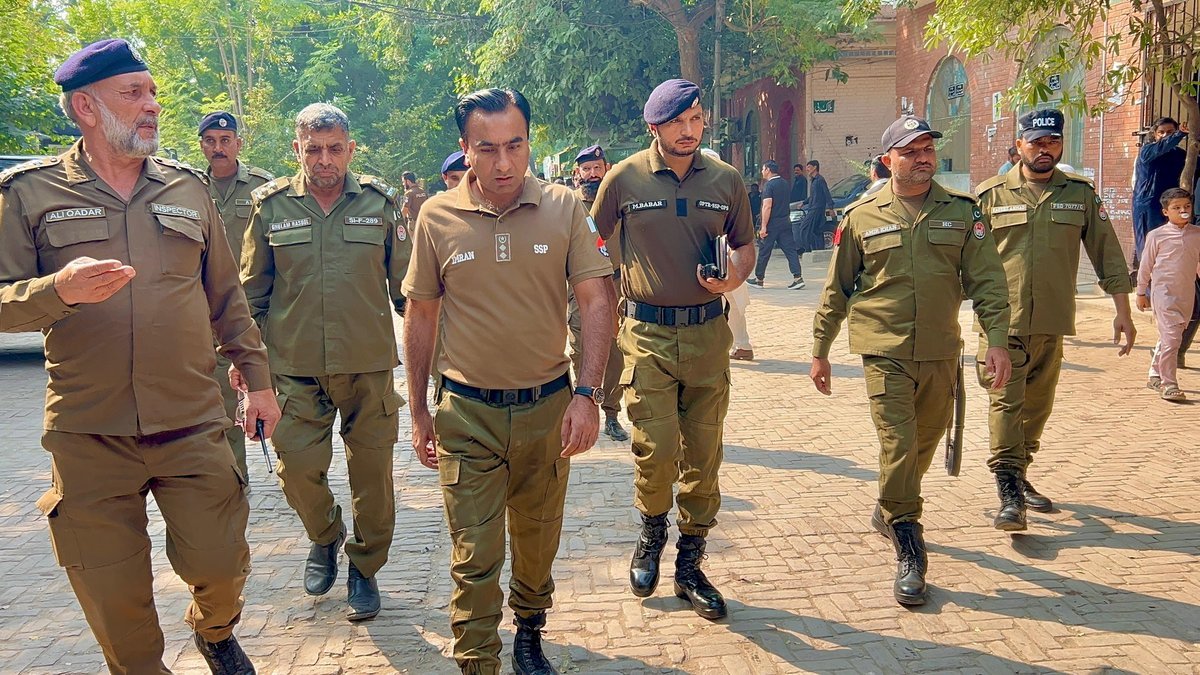 SSP Operations Imran Ahmad Malik walks with officers during his inspection of the sessions court lockup in Faisalabad.