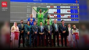 Pakistan Police weightlifter celebrates on the podium with the national flag