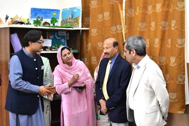 The vice chancellor talks with teachers during the visit
