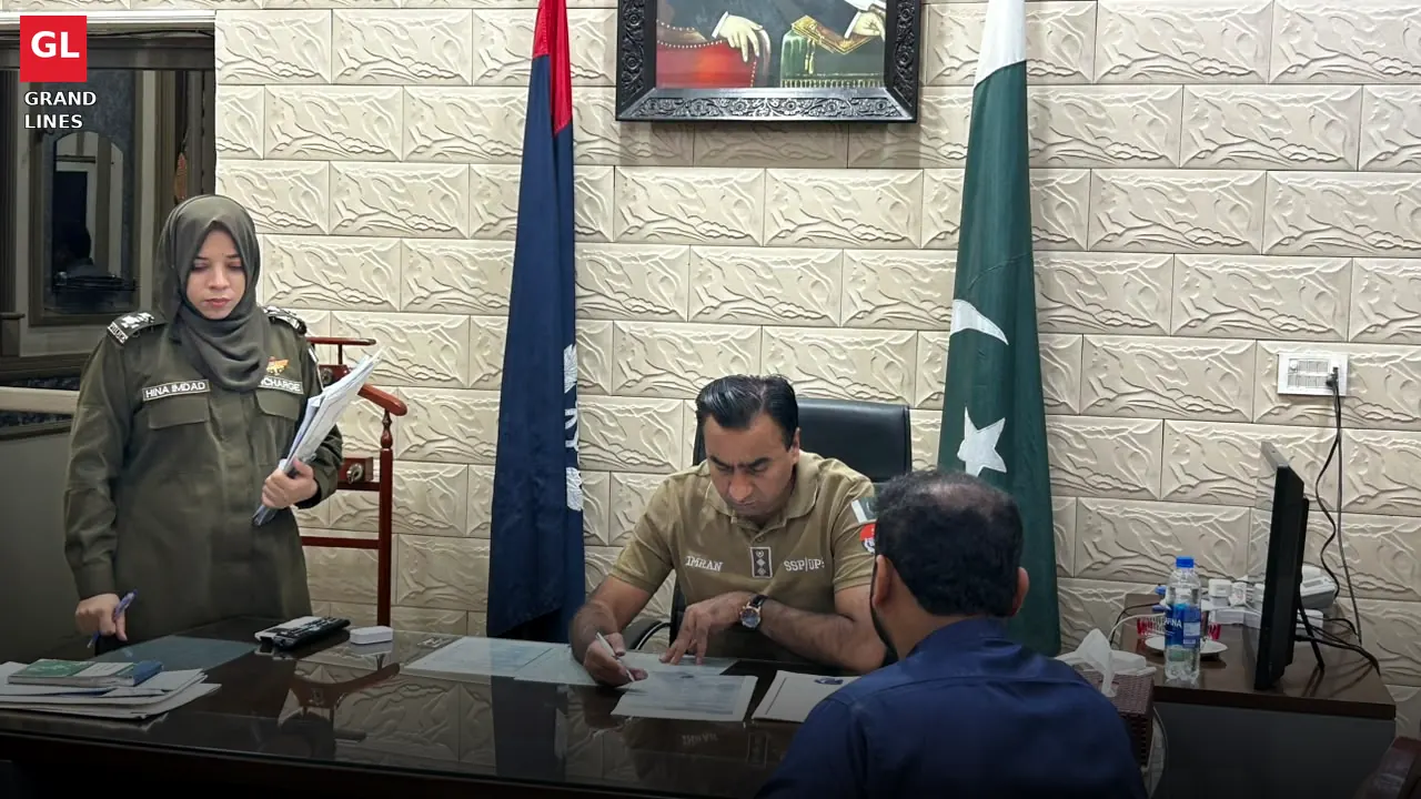 A lady officer assists with case files as SSP Operations Imran Ahmad Malik hears an applicant at the open court.