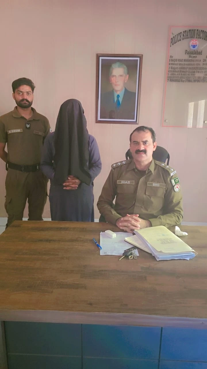 An arrested suspect with police at Factory Area police station in Faisalabad.